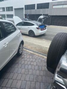 Professional checking car seatbelts during a roadworthiness test in QLD